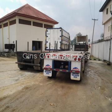Flatbed trailers marshalled beside branded reefer containers