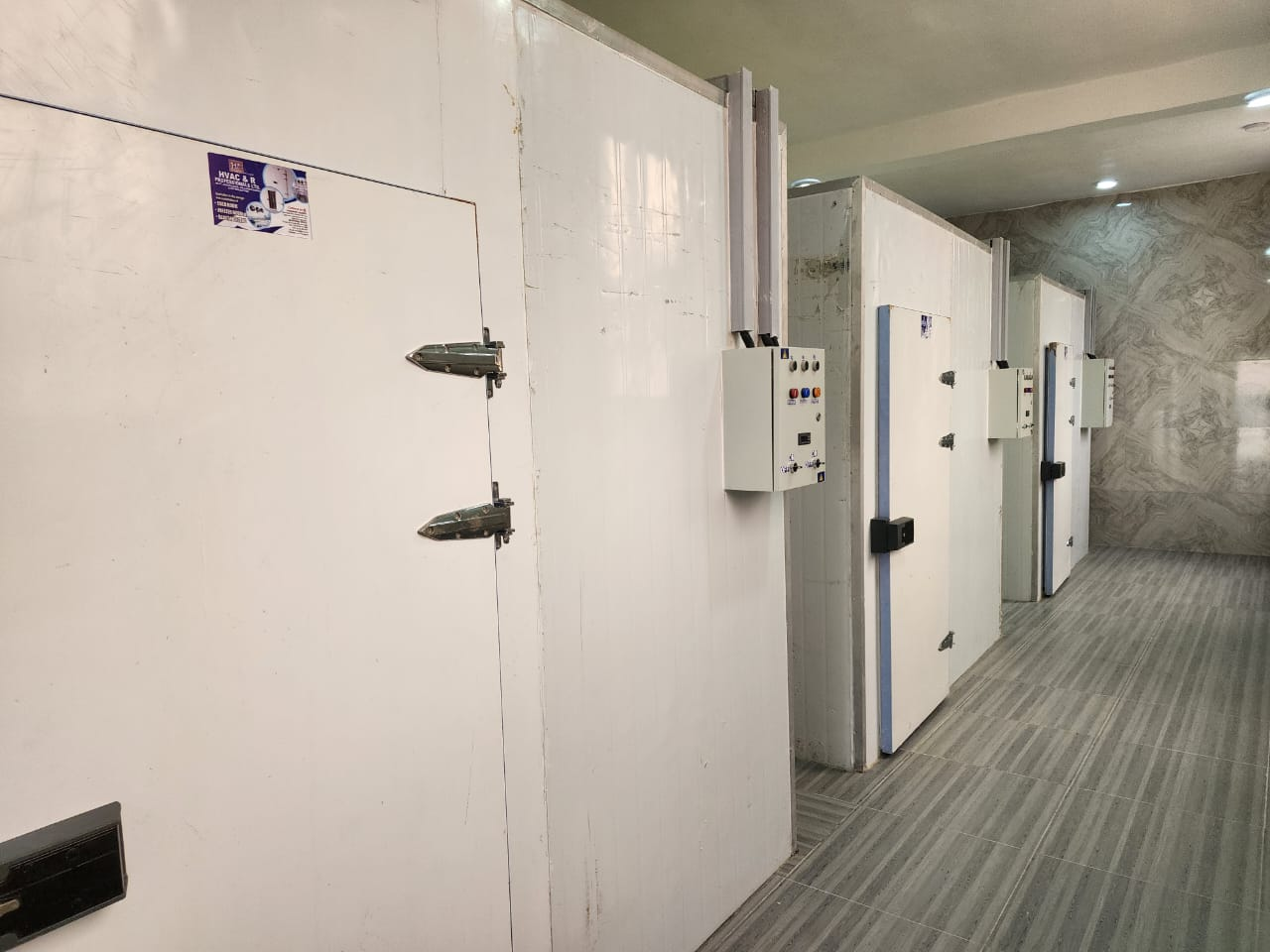 Industrial walk-in freezer and chiller rooms with digital temperature control panels at Gins Global's Iriebe base