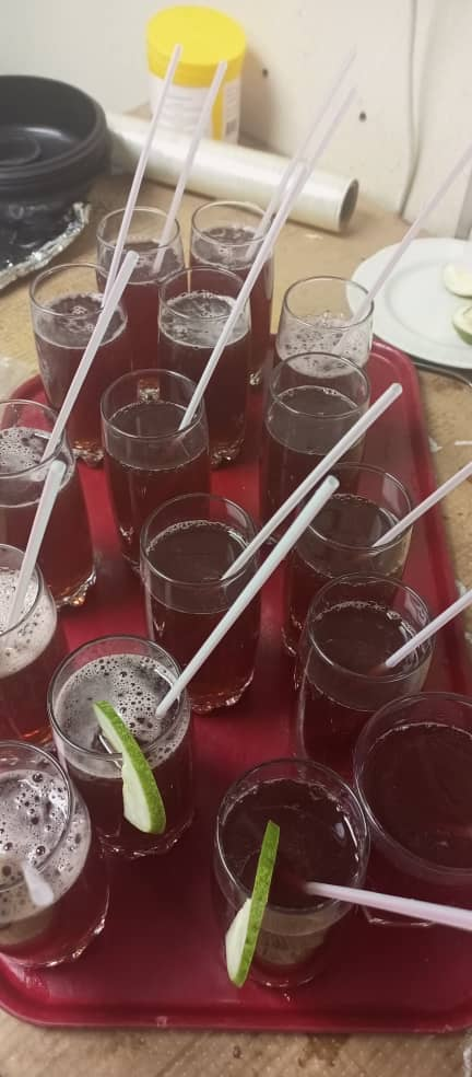 Chilled zobo welcome drinks garnished with lime, plated on service trays